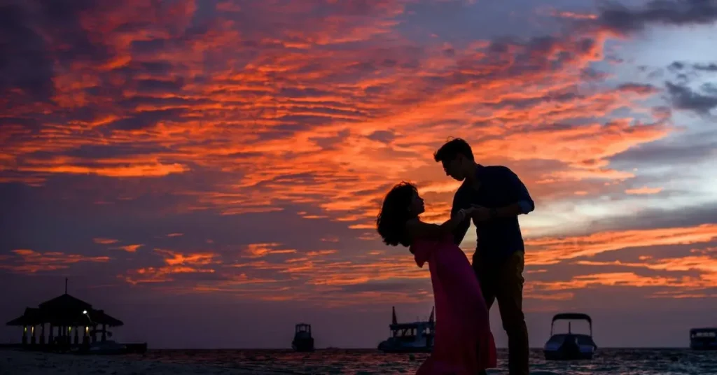 a dancing couple in front of a sunset as a couple pose reference