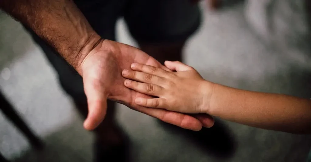 a child placing her hand in a mans hand as Father's Day Drawing Ideas