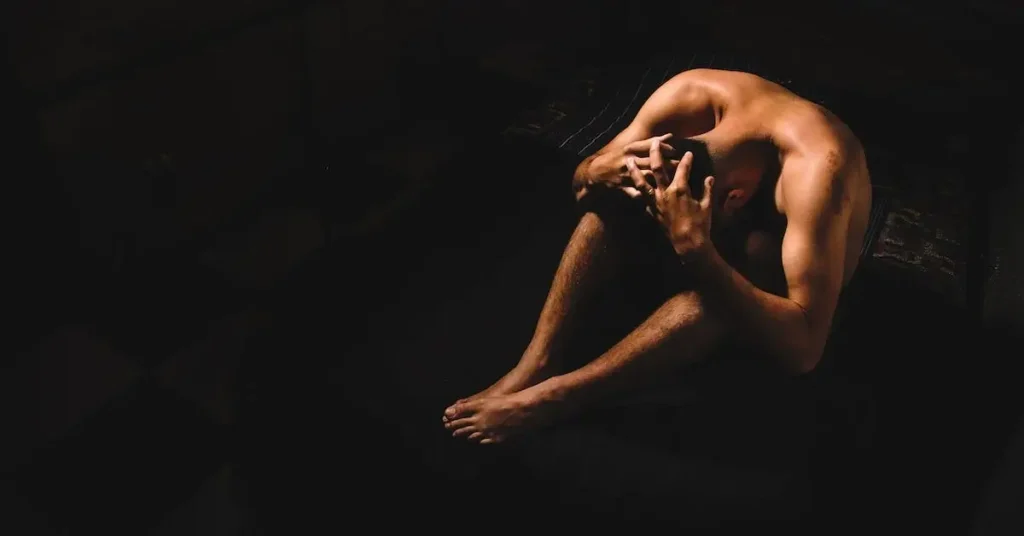nude man sitting on the floor as a Male Pose Reference